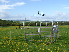 A measuring station at another study site in Thuringia (Hainich-Dün) with scientists taking samples in the background (photo: Beatrix Schnabel)